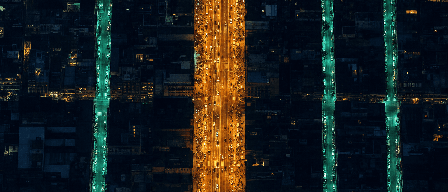 Aerial night city: one crowded golden boulevard beside quiet teal side streets lighting up